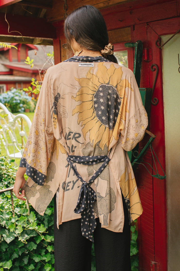 Model wearing our matinee length kimono featuring vintage-inspired Milk & Honey print with 1904 typography and floral woodcuts – Market of Stars
