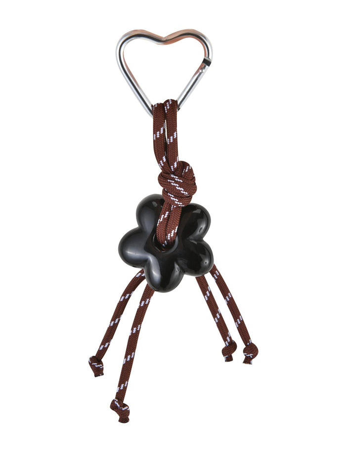 The MIRIAM KEYCHAIN - CHOCOLATE from TIGERMIST features a heart-shaped clasp carabiner securing an artfully knotted brown rope around a black flower charm, with four knotted ends cascading downward. This elegant yet functional piece is perfect for your keychain collection.