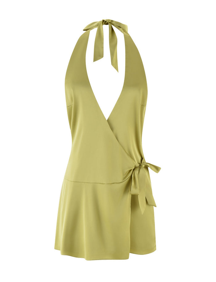 The MONROE 2.0 MINI DRESS in pistachio from TIGERMIST is a sleeveless, light green halter neck dress with a deep V-neckline and a wrap-style design. It includes a knot tied at the side of the waist, creating a layered, flowing look at the hem reminiscent of satin wrap attire.