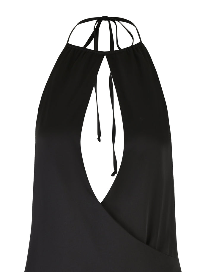 A close-up view of the TIGERMIST MONROE DRESS - BLACK showcases its sleek, black colorway, featuring a halter neck top with a keyhole cutout design in the front and thin straps that tie at the neck. The fabric appears smooth and slightly shiny.
