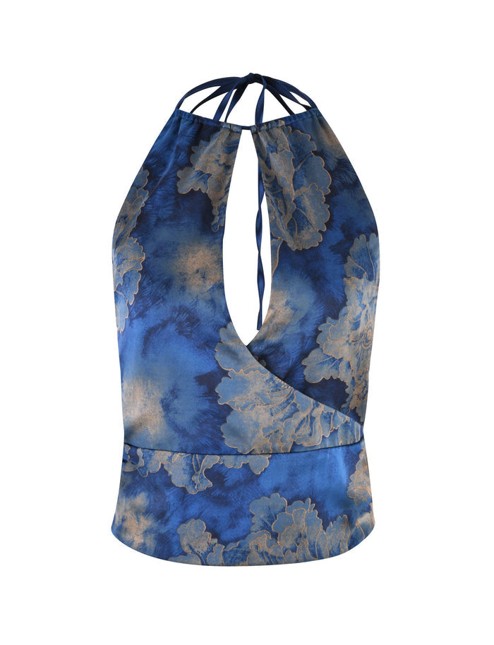 The MONROE TOP - BLUE : FLORAL by TIGERMIST features a sleeveless halter neckline with a blue floral watercolor pattern. It showcases an open keyhole front design and is secured with thin straps that tie at the back.