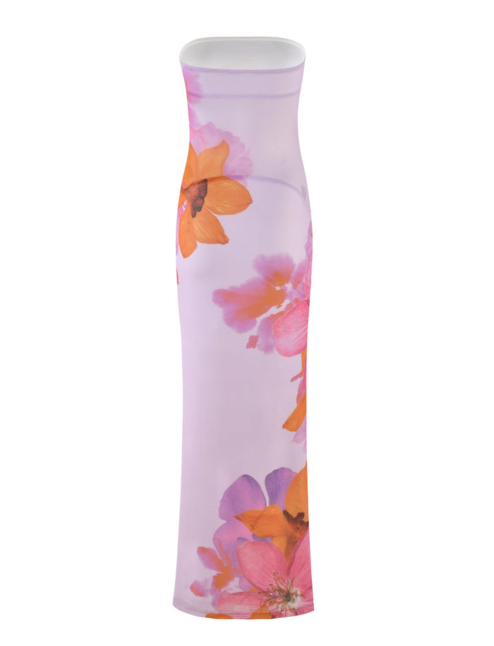 The Morgan Dress from Tigermist's By Poppy Summer collection is a strapless bodycon dress featuring a vibrant floral print on a pink background. The design showcases large, colorful flowers in shades of orange, pink, and purple, creating an eye-catching and elegant look.