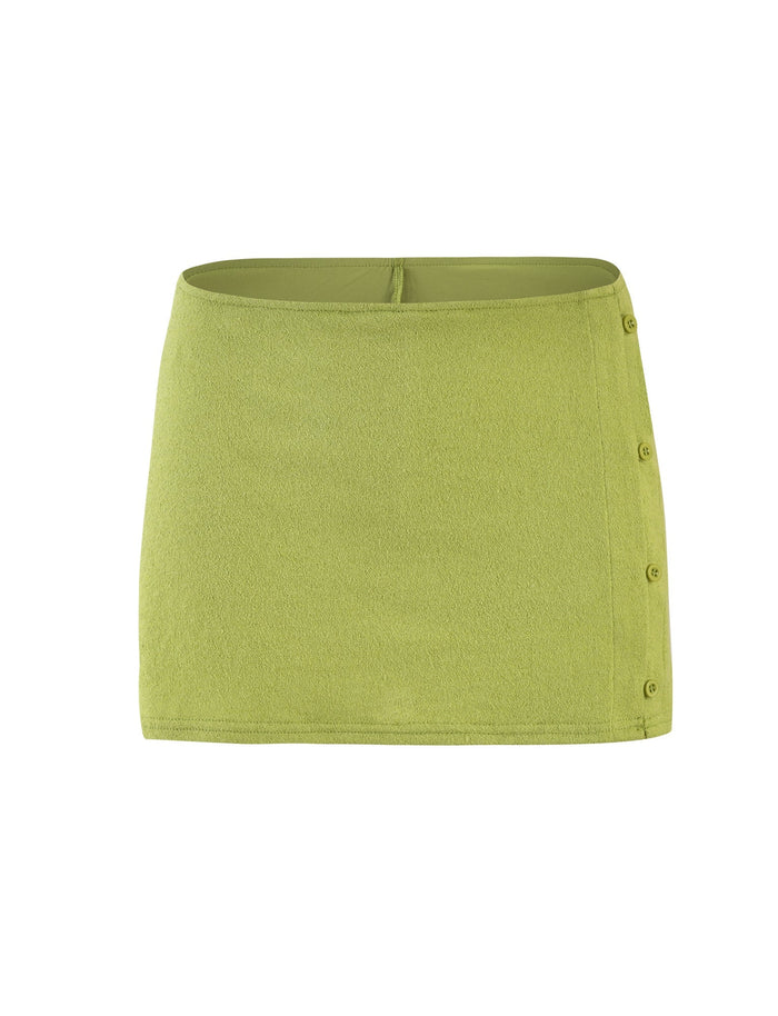 The OAKLEE SKORT in Matcha Green from TIGERMIST is crafted from soft fabric and boasts a light green hue. It features a high-rise waistband and side button details on the right side, adding a stylish touch to its simple design.