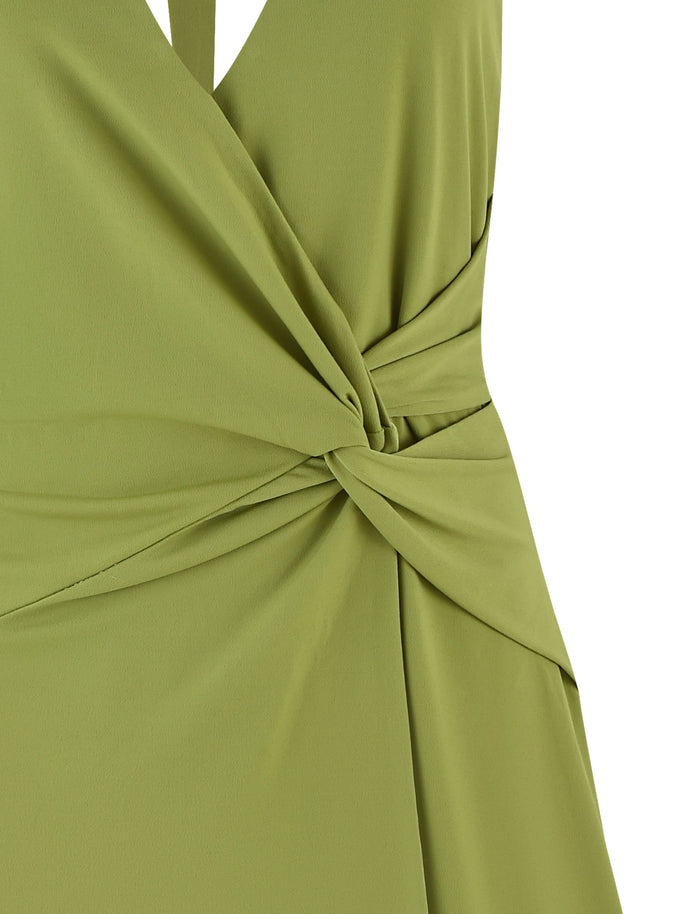 Close-up of the PARRIS DRESS - GREEN by TIGERMIST, featuring a stylish knot detail at the waist. The smooth fabric drapes elegantly, highlighting the beautiful twist detailing.