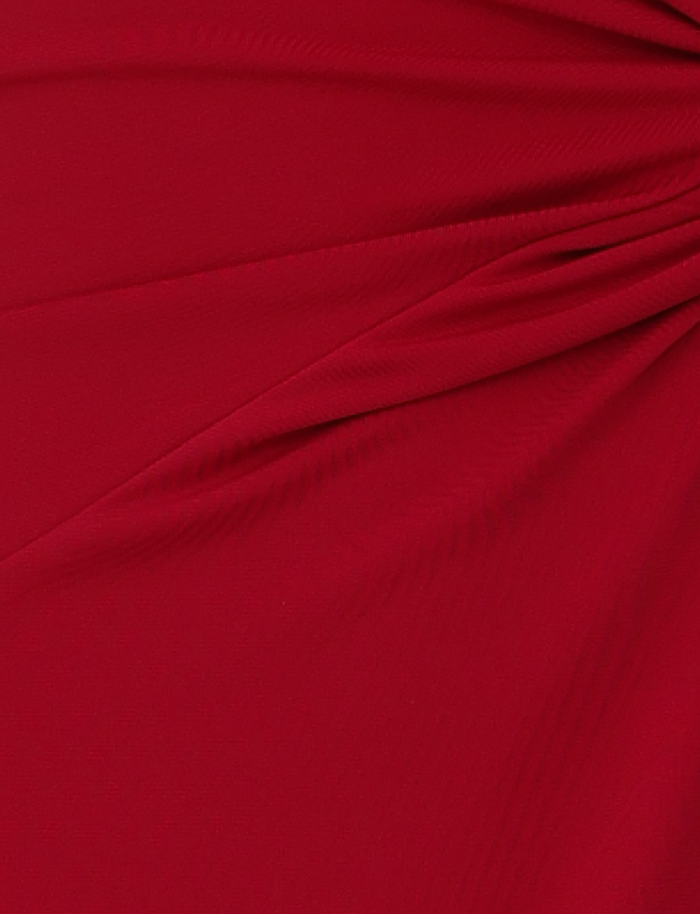 Close-up of the PARRIS DRESS in red by TIGERMIST, featuring soft fabric with gentle folds and pleats for a textured, layered look. Subtle shadows highlight the dress’s smooth, draped effect.