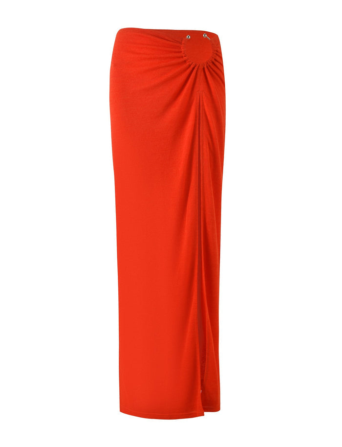 The PAXTON SKIRT - RED : OMBRE by TIGERMIST is a vibrant red mesh maxi skirt featuring a high-waisted design with gathered fabric at the waist for a subtle ruched effect. It boasts a stylish high split and slightly asymmetrical drape, offering a chic and contemporary appearance.