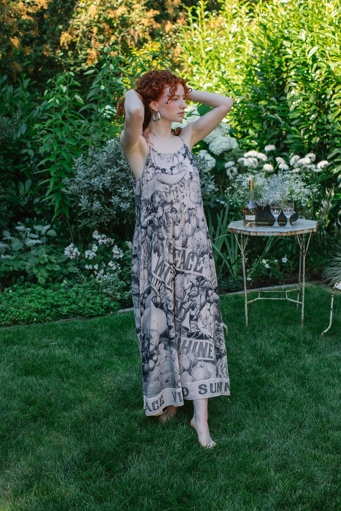 Model wearing Peace, Wine & Sunshine Bohéme Slip Dress featuring botanical collages and playful peace, wine and sunshine lettering on the hem – Market of Stars.