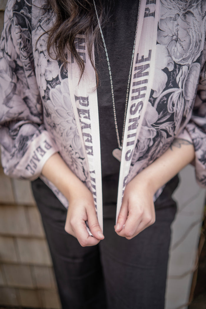 Model wearing Peace, Wine & Sunshine Bohéme Slip Dress featuring botanical collages and playful peace, wine and sunshine lettering on the hem – Market of Stars.