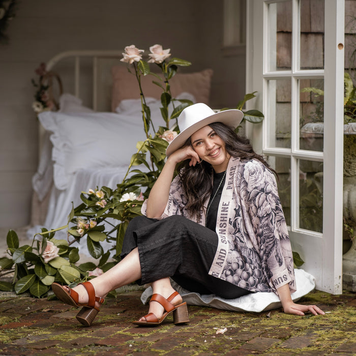 Model wearing Peace, Wine & Sunshine Bohéme Slip Dress featuring botanical collages and playful peace, wine and sunshine lettering on the hem – Market of Stars.