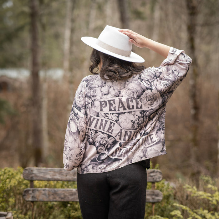 Model wearing Peace, Wine & Sunshine Bohéme Slip Dress featuring botanical collages and playful peace, wine and sunshine lettering on the hem – Market of Stars.