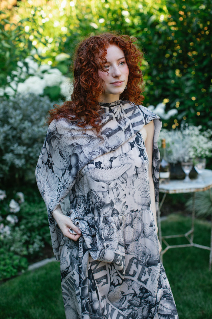Model wearing Peace, Wine & Sunshine Bohéme Slip Dress featuring botanical collages and playful peace, wine and sunshine lettering on the hem – Market of Stars.