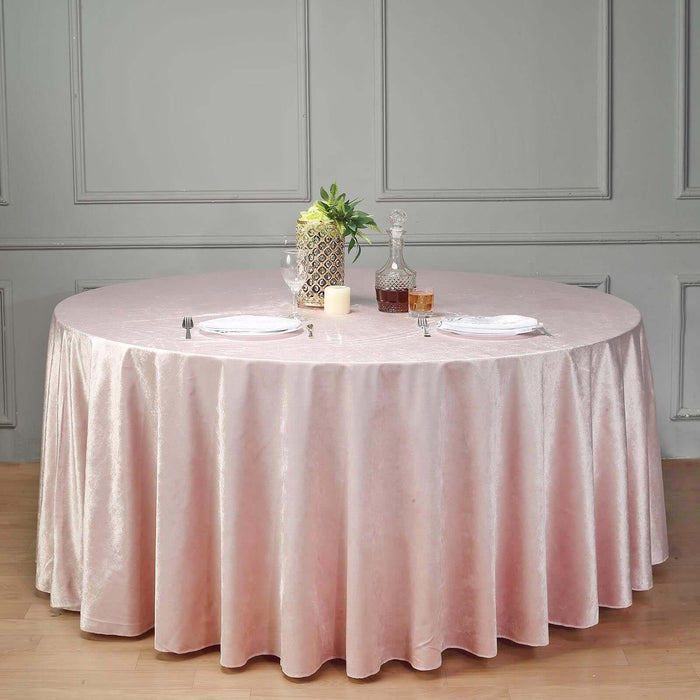 Round table with pink tablecloth, decorative items, and elegant setting.