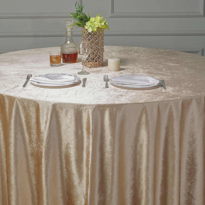 Elegant gold tablecloth draped over a round table set for dining.