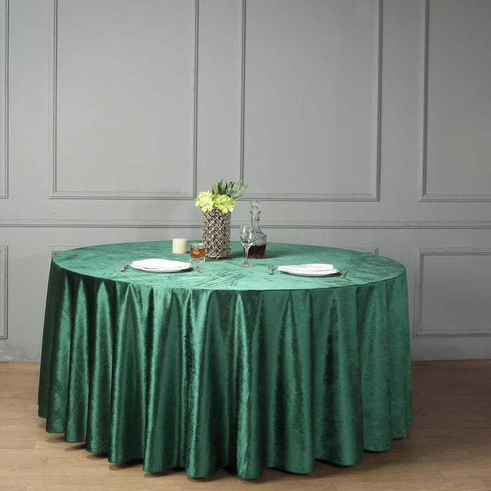 Round green tablecloth draped elegantly over a table with centerpiece decor.