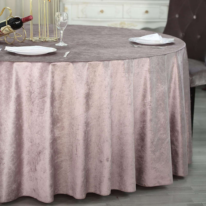 Elegant round table with a soft mauve velvet tablecloth and dining setup.