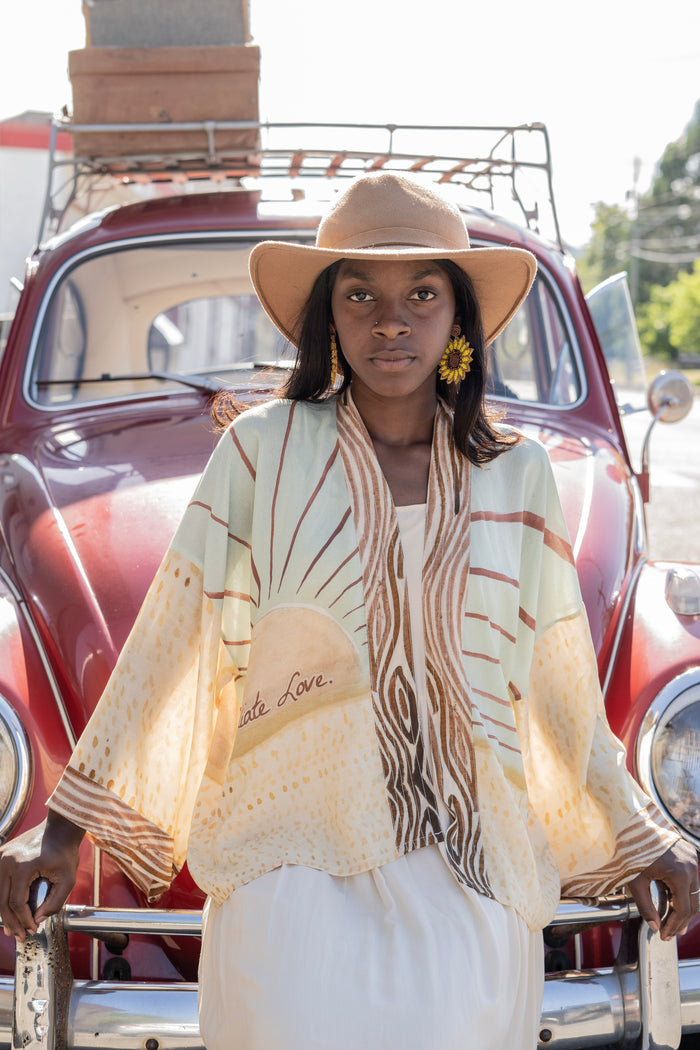 Model wearing Peace, Wine & Sunshine Bohéme Slip Dress featuring botanical collages and playful peace, wine and sunshine lettering on the hem – Market of Stars.