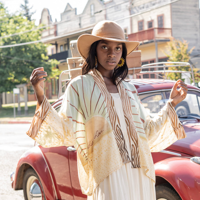Model wearing Peace, Wine & Sunshine Bohéme Slip Dress featuring botanical collages and playful peace, wine and sunshine lettering on the hem – Market of Stars.