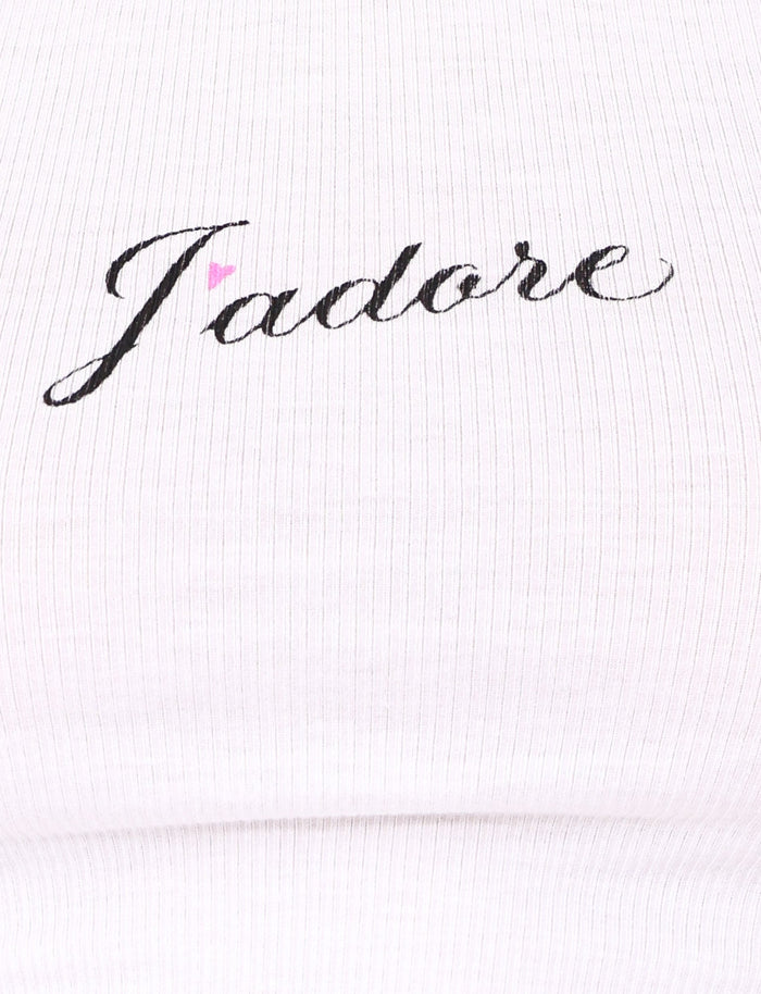 Close-up of the RAFAELLA TANK - WHITE by TIGERMIST, a white ribbed racerback tank top with a black cursive J'Adore graphic and a small pink heart above the "a".