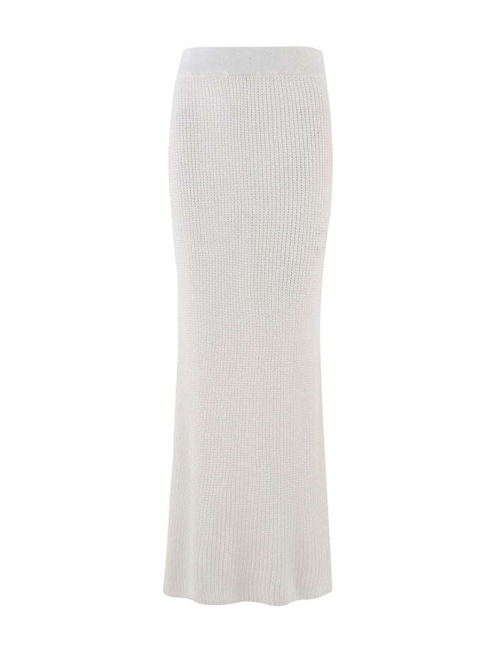 The RAMSEY SKIRT in white by TIGERMIST is a long knit skirt with a light gray hue and a straight, fitted silhouette. It features an elasticated waistband and a seamless look, along with a subtle ribbed texture extending to ankle-length. Its classic design stands out against the plain white background.