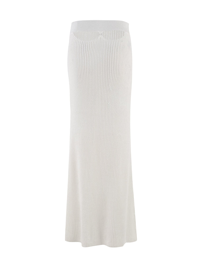 Introducing the RAMSEY SKIRT - WHITE by TIGERMIST: A maxi-length, cream-toned knit skirt that showcases a minimalist design with subtle texture and a gentle flare at the bottom. Its elasticated waistband provides comfort, enhancing its elegance and versatility, making this skirt a seamless addition to any outfit.