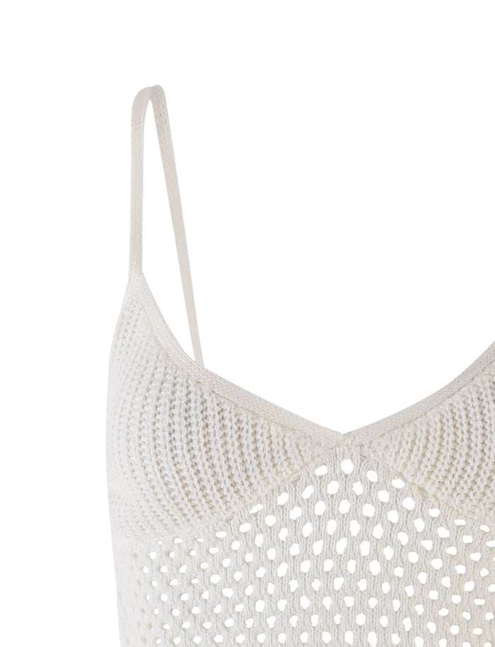 Close-up of the RAMSEY TOP - WHITE by TIGERMIST, showcasing its white crochet finish with thin, adjustable shoulder straps and a textured, airy design. The fabric highlights a pattern of small, evenly spaced holes and features a stylish crop length.