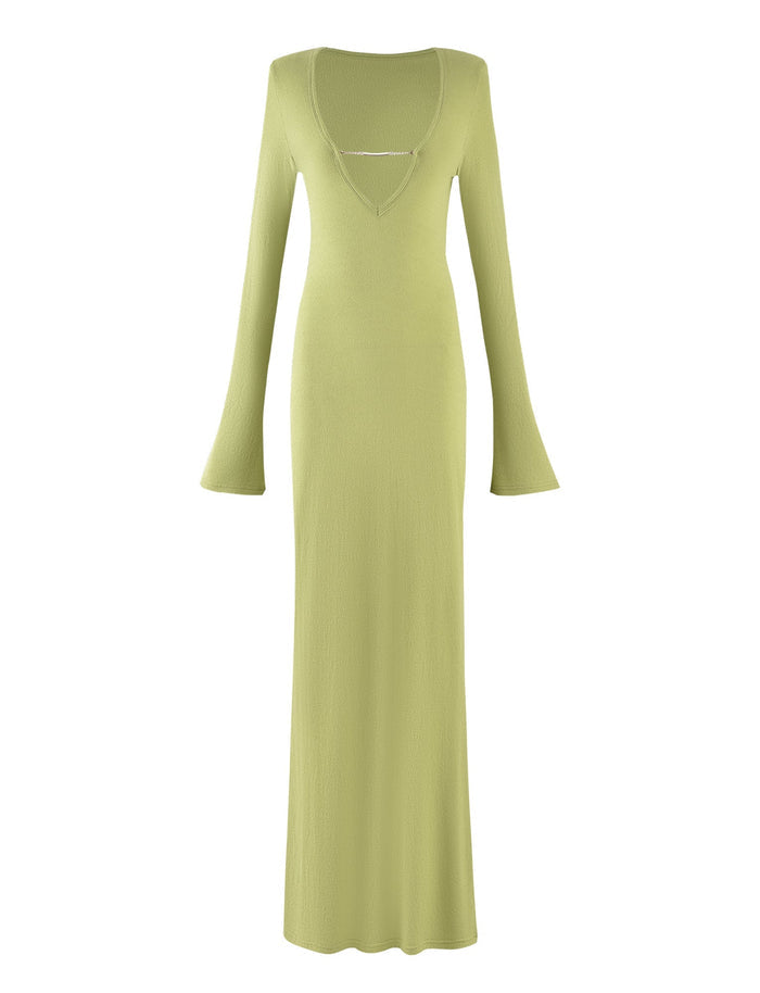 The ROMIE DRESS - GREEN : MATCHA GREEN from Tigermist is a long, light green dress featuring flared sleeves and a V-neckline adorned with a small, delicate chain detail across the chest. This dress showcases a slim, floor-length silhouette and embodies a simple yet elegant design.