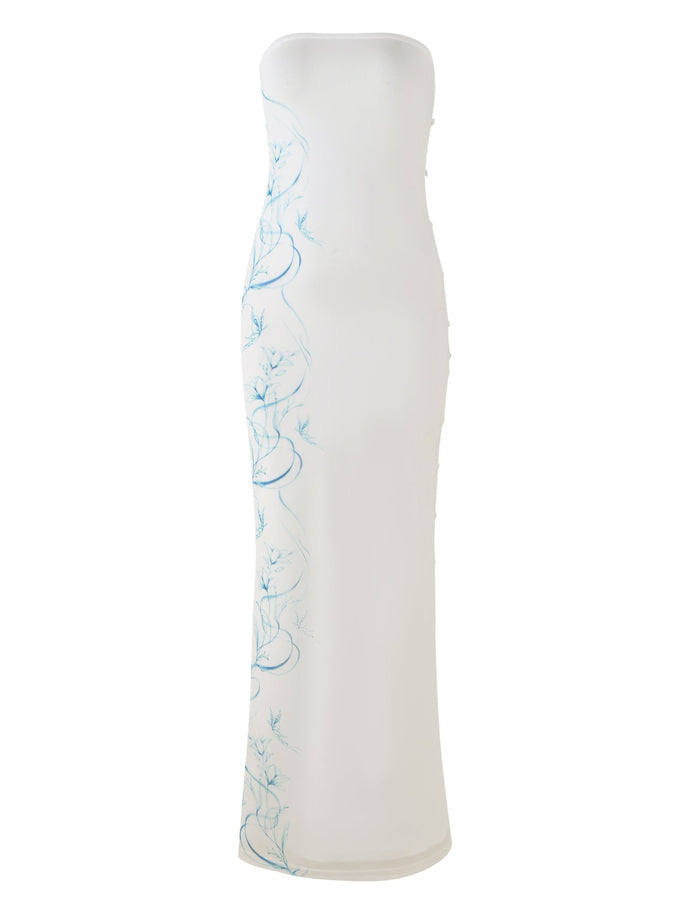 The ROMINA MESH DRESS - WHITE by TIGERMIST is a stunning sleeveless, strapless gown with a fitted silhouette. It features a light blue floral print along the side and boasts a floor-length design with a slight train.