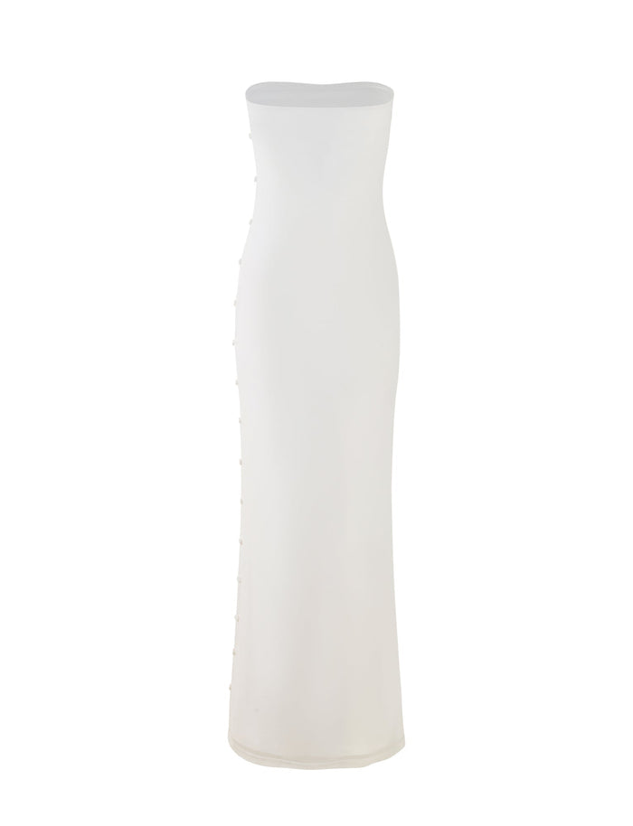 The ROMINA MESH DRESS - WHITE by TIGERMIST is a long, strapless dress with a fitted silhouette. It features a straight neckline and small decorative buttons along the side. The fabric appears to be smooth and slightly stretchy, contributing to its simple and elegant design.