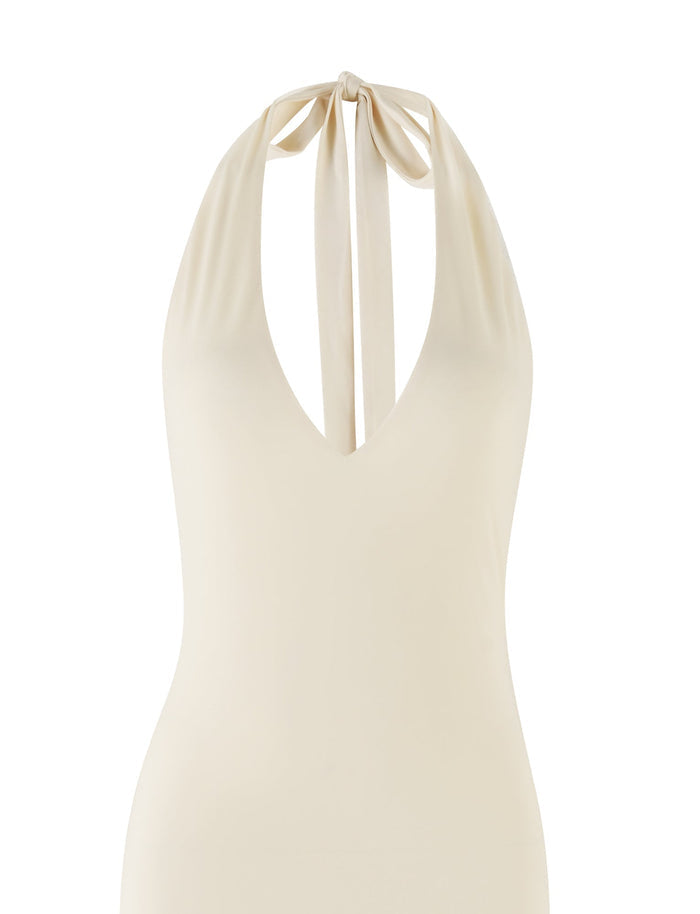 The ROZLYNN DRESS in a butter yellow shade by TIGERMIST features a halter-neck design with a deep V-neckline and maxi length. The straps are elegantly tied in a bow at the back of the neck, creating graceful gathers at the top, and the smooth fabric offers a slightly fitted appearance.