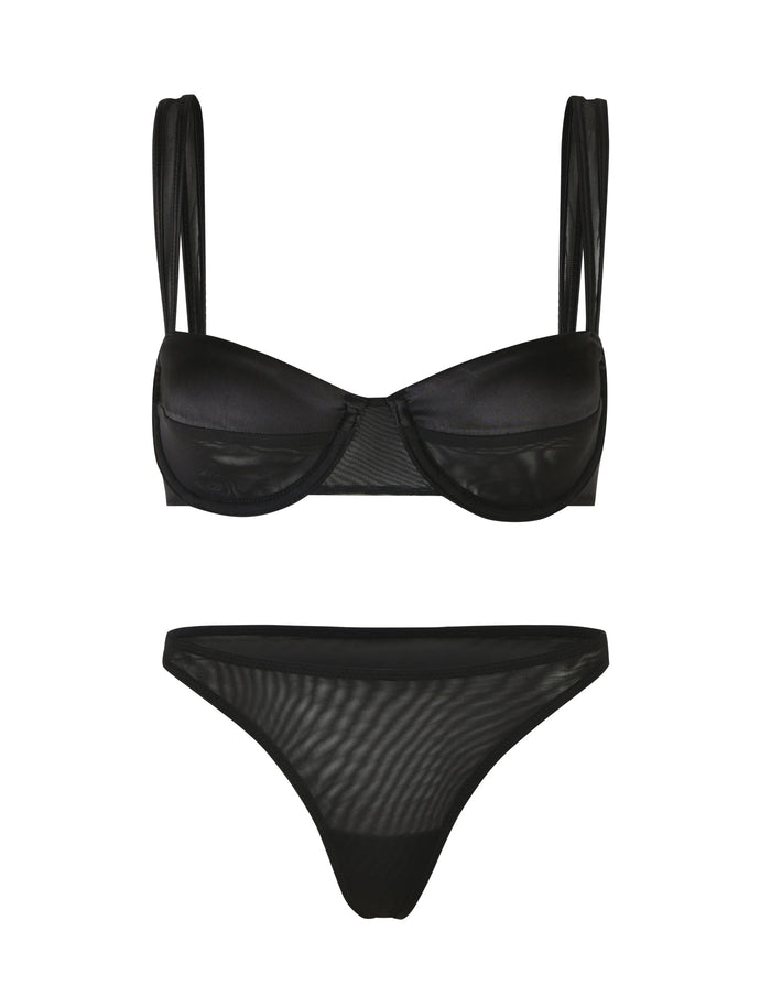 The TIGERMIST SAFFRON SET 2.0 - BLACK is a bikini set showcased against a white backdrop. The top boasts a balconette shape with underwire cups and double shoulder straps, perfectly complementing the mid-rise bottoms crafted from semi-sheer material. This design effortlessly achieves a sleek and sensual look.