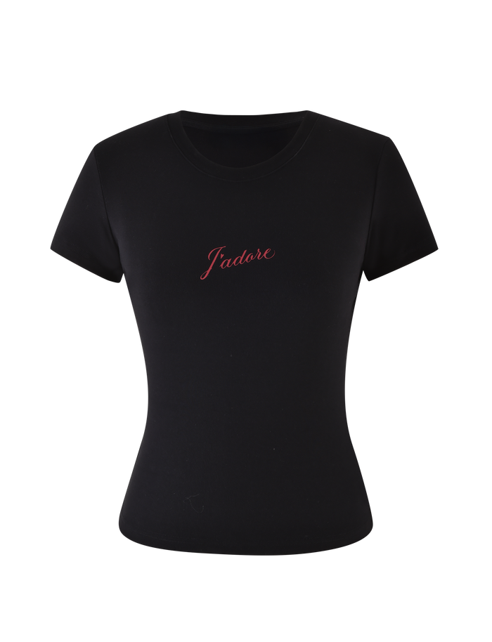 The SAPHIRA TEE - BLACK by TIGERMIST is a fitted black tee crafted from high-stretch fabric, with a bold red cursive J'Adore graphic across the chest.