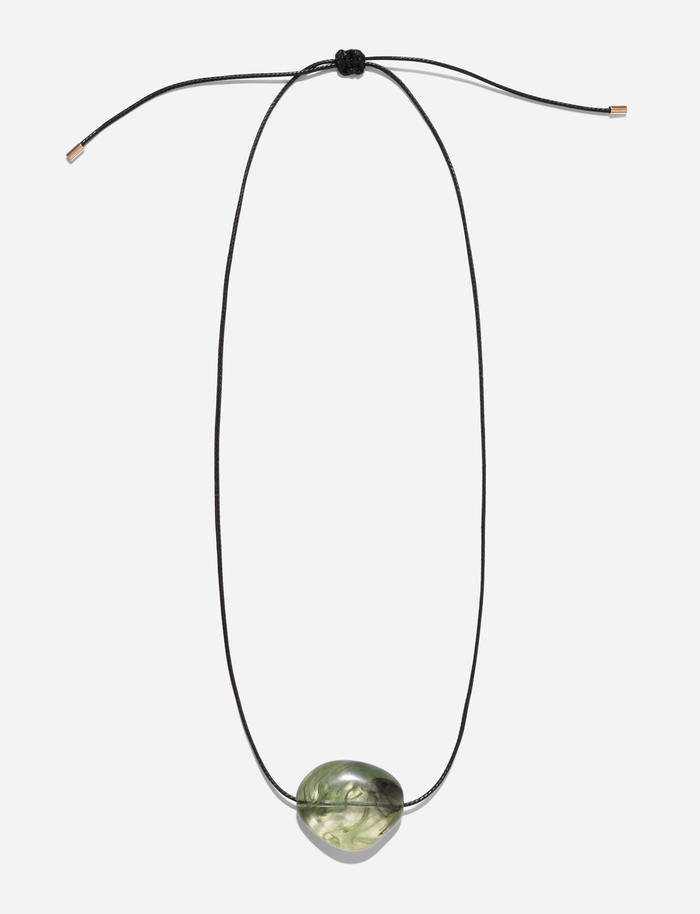 The SOLENE NECKLACE - GREEN by TIGERMIST features a black woven adjustable cord and a single polished green stone pendant, shown against a plain white background.