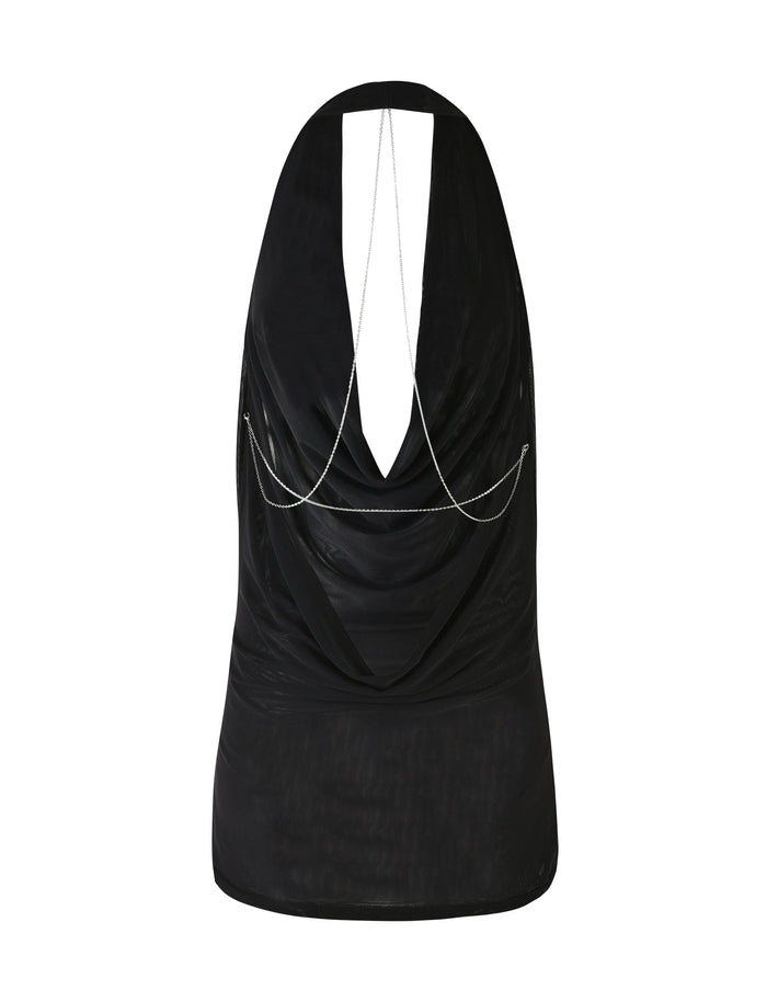 A sleeveless black mini dress from TIGERMIST, called the SONORA MINI DRESS - BLACK, featuring a halter top style with a cowl neck. The back showcases a draped open design adorned with thin silver chain detailing in a crisscross pattern. The fabric is soft and slightly sheer.