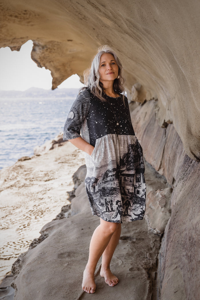 Model wearing a celestial knee-length artist dress in bamboo & wood blend viscose ft. the 1833 Leonid meteor shower in a dreamy star-filled night sky - Market of Stars.