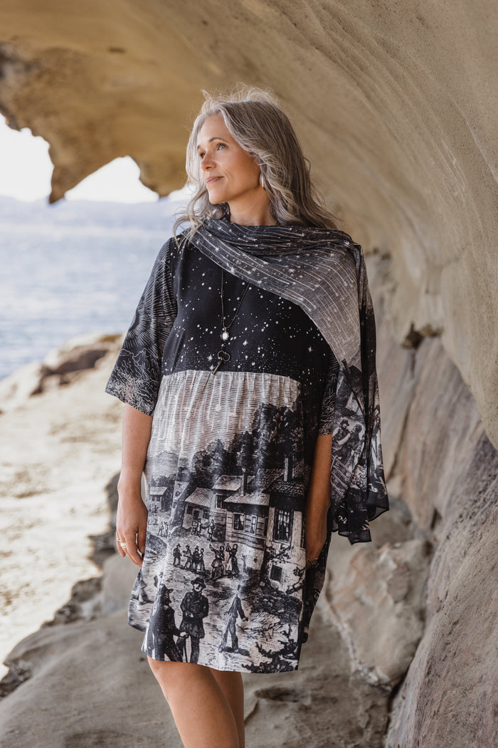 Model wearing a celestial knee-length artist dress in bamboo & wood blend viscose ft. the 1833 Leonid meteor shower in a dreamy star-filled night sky - Market of Stars.