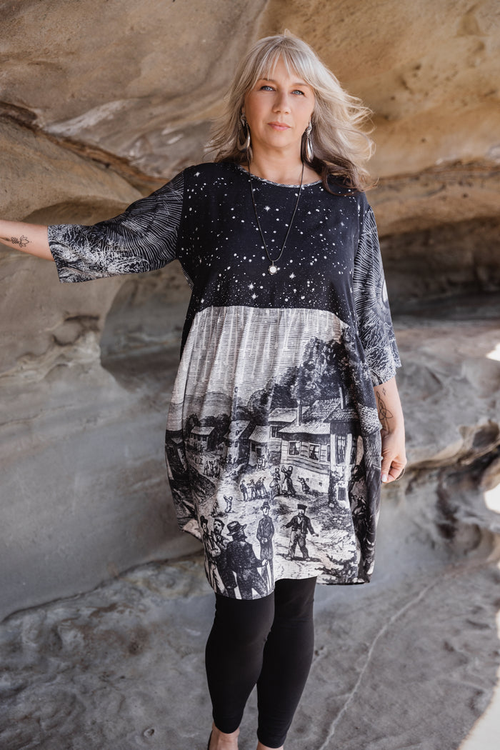 Model wearing a celestial knee-length artist dress in bamboo & wood blend viscose ft. the 1833 Leonid meteor shower in a dreamy star-filled night sky - Market of Stars.