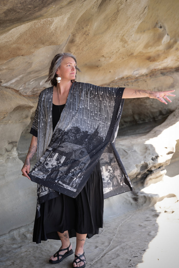 Model wearing a celestial flowy kimono duster in bamboo & wood blend viscose ft. the 1833 Leonid meteor shower in a dreamy star-filled night sky - Market of Stars.