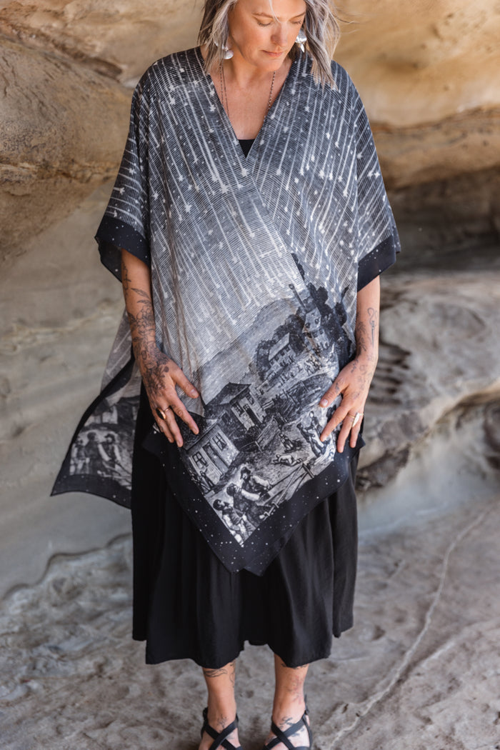Model wearing a celestial flowy kimono duster in bamboo & wood blend viscose ft. the 1833 Leonid meteor shower in a dreamy star-filled night sky - Market of Stars.