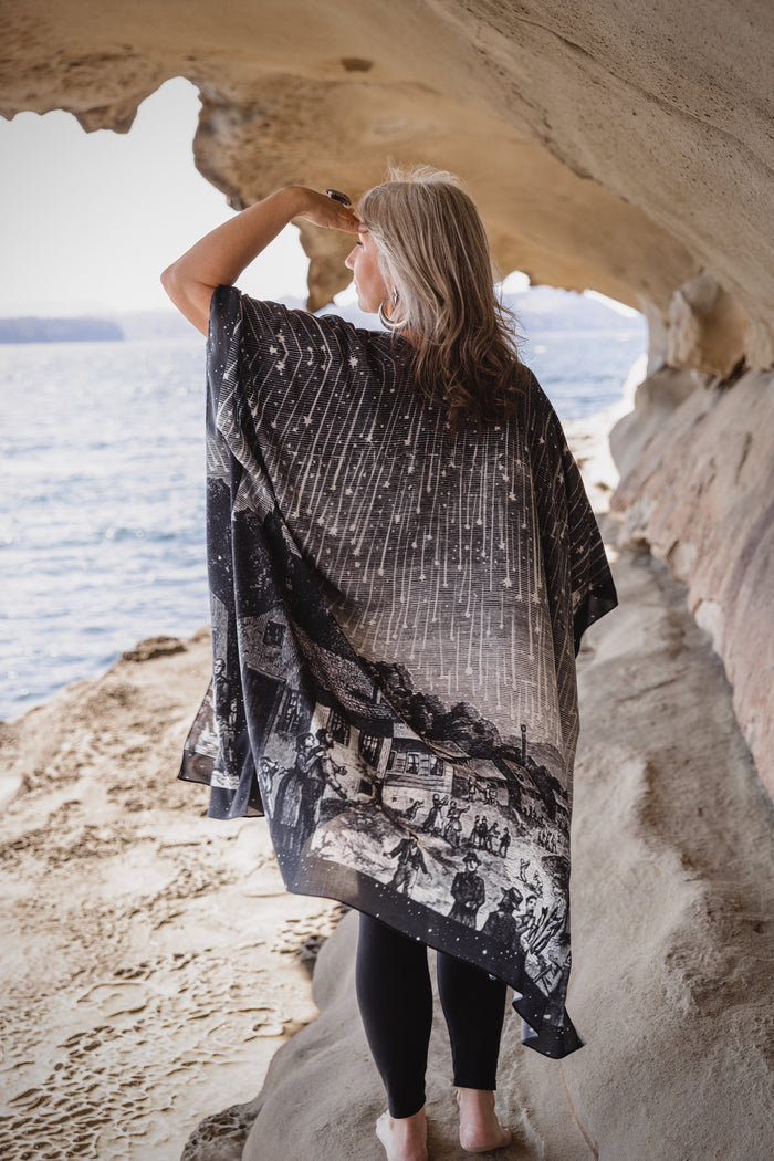 Model wearing a celestial flowy kimono duster in bamboo & wood blend viscose ft. the 1833 Leonid meteor shower in a dreamy star-filled night sky - Market of Stars.