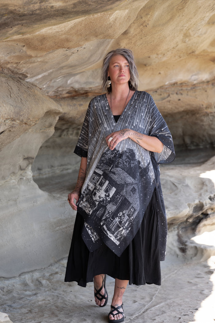 Model wearing a celestial flowy kimono duster in bamboo & wood blend viscose ft. the 1833 Leonid meteor shower in a dreamy star-filled night sky - Market of Stars.