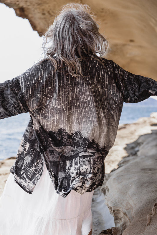 Model wearing a celestial mid-length kimono duster in bamboo & wood blend viscose ft. the 1833 Leonid meteor shower in a dreamy star-filled night sky - Market of Stars.