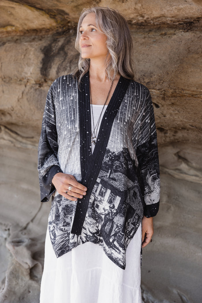 Model wearing a celestial mid-length kimono duster in bamboo & wood blend viscose ft. the 1833 Leonid meteor shower in a dreamy star-filled night sky - Market of Stars.