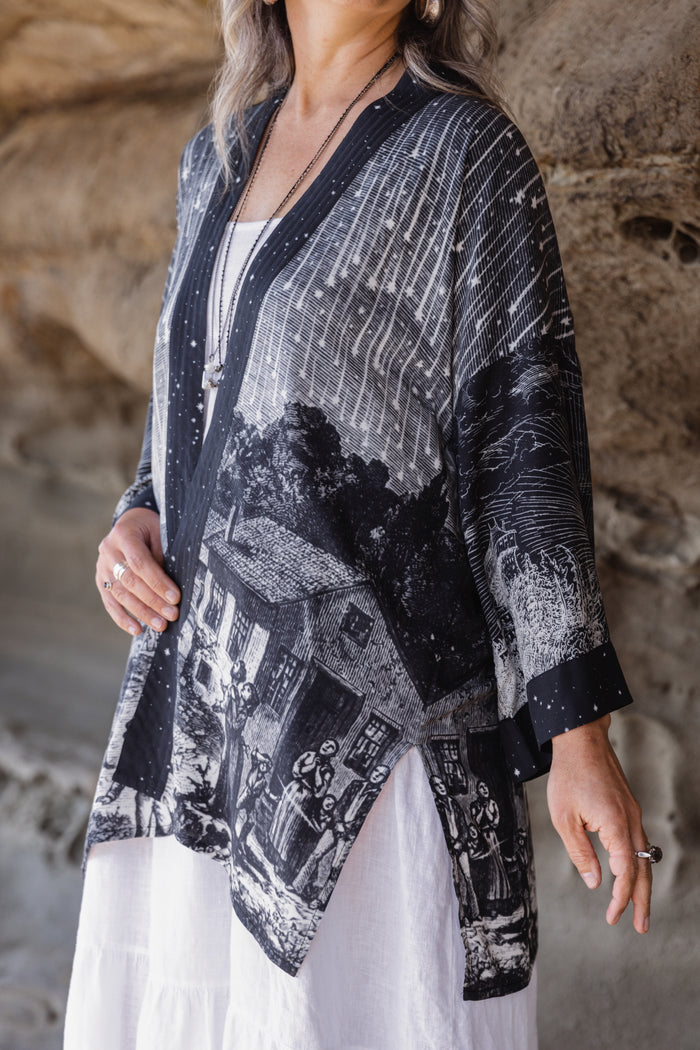 Model wearing a celestial mid-length kimono duster in bamboo & wood blend viscose ft. the 1833 Leonid meteor shower in a dreamy star-filled night sky - Market of Stars.