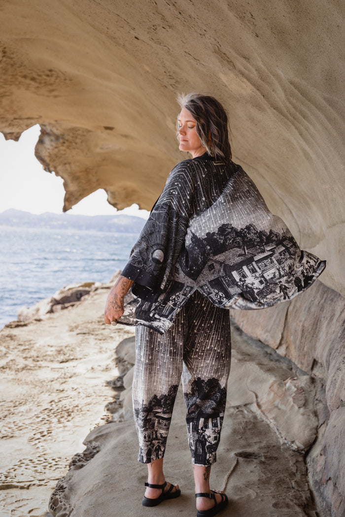 Model wearing a celestial mid-length kimono duster in bamboo & wood blend viscose ft. the 1833 Leonid meteor shower in a dreamy star-filled night sky - Market of Stars.