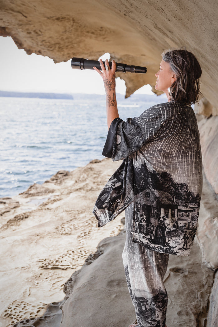 Model wearing a celestial mid-length kimono duster in bamboo & wood blend viscose ft. the 1833 Leonid meteor shower in a dreamy star-filled night sky - Market of Stars.