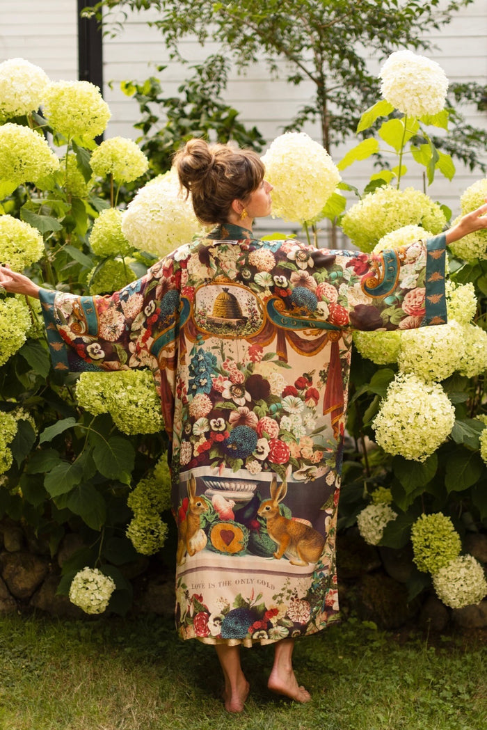 Model wearing Stay Gold Opera Duster with wildflower, bee, and bunny rabbit illustrations, golden script, and vintage collage in full-length kimono silhouette – Market of Stars