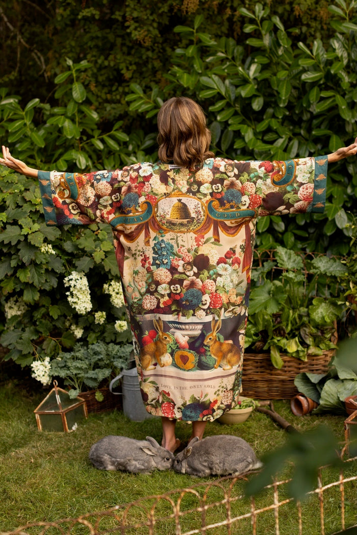 Model wearing Stay Gold Opera Duster with wildflower, bee, and bunny rabbit illustrations, golden script, and vintage collage in full-length kimono silhouette – Market of Stars