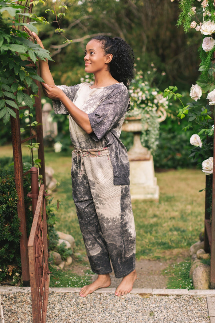Model wearing the Still I Rise Luxe Tee with wide scoop neck and soft bamboo-based viscose, featuring vintage landscape etching and an inspiring message – Market of Stars