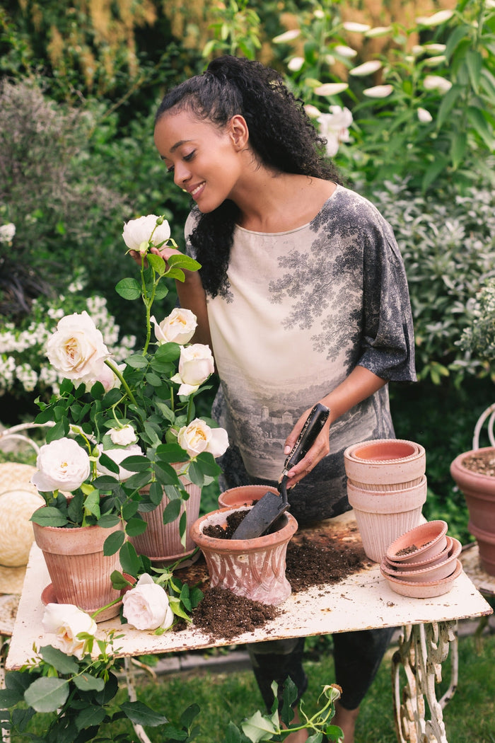 Model wearing the Still I Rise Luxe Tee with wide scoop neck and soft bamboo-based viscose, featuring vintage landscape etching and an inspiring message – Market of Stars