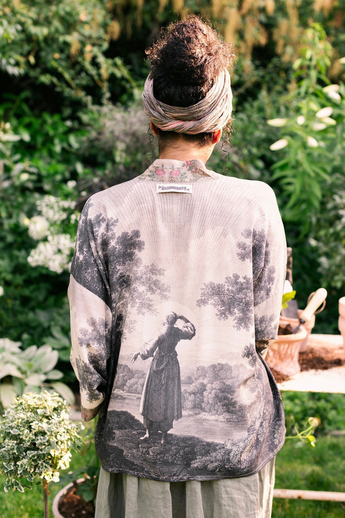 Model wearing our Still I Rise Pixie Duster with empowering message a bold, layered design featuring antique landscape etchings – Market of Stars